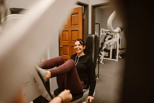A woman on an exercise machine for glute strengthening.