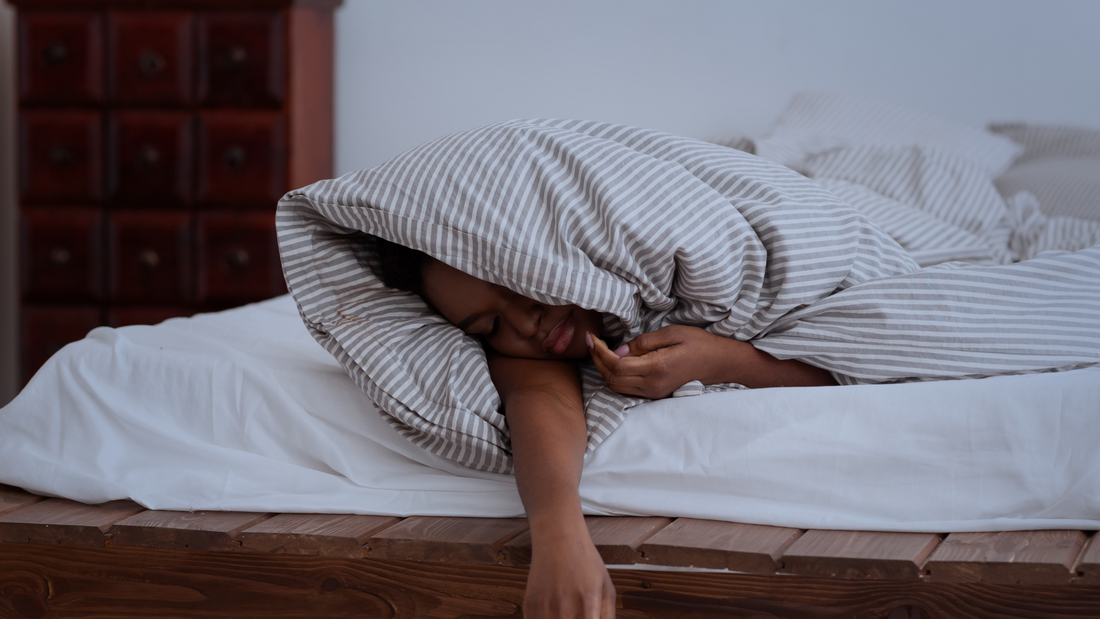 man sleeping with his hand over the bed