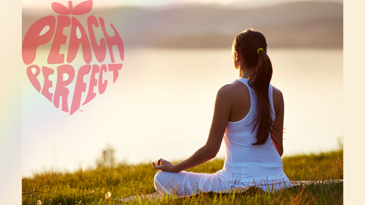 Woman doing a yoga pose facing the sunset on the grass